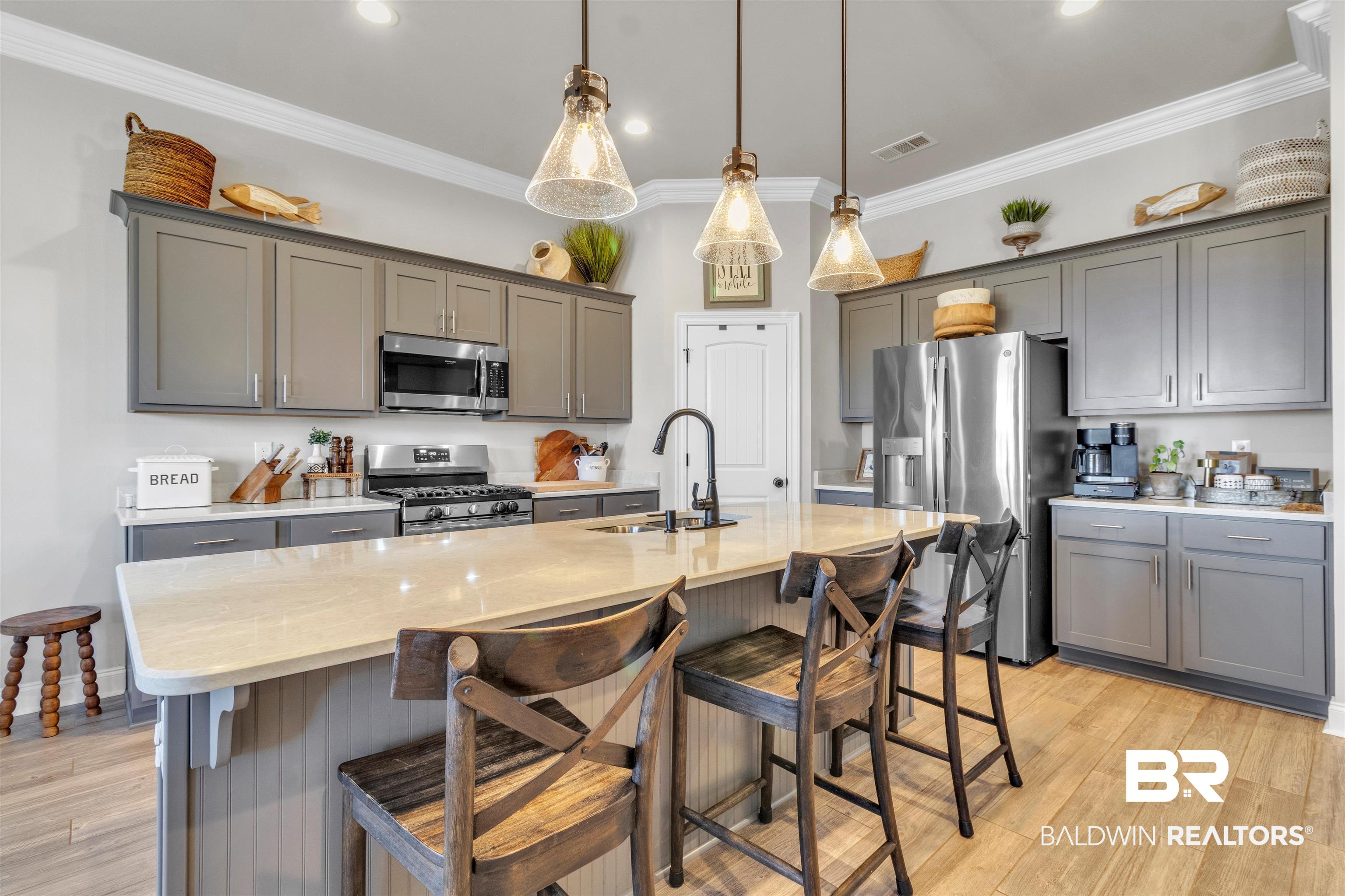 22531 Putter Lane Foley, AL 36535 - Photo 8 of 43 Kitchen with gray cabinets, a kitchen breakfast bar, stainless steel appliances, and ornamental molding