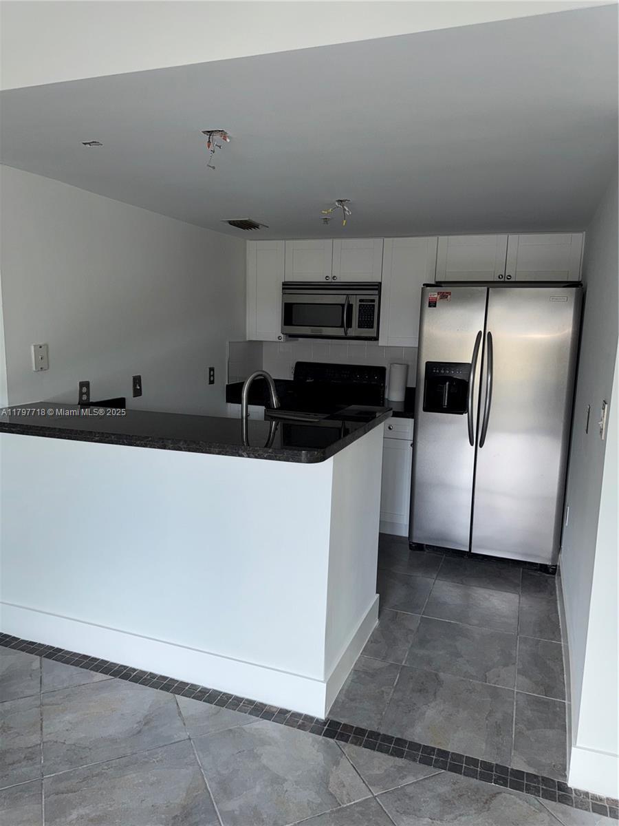 498 Southwest 2nd Street, Unit 2D Miami, FL 33130 - Photo 15 of 35 a kitchen with stainless steel appliances a refrigerator a sink a stove a microwave and cabinets
