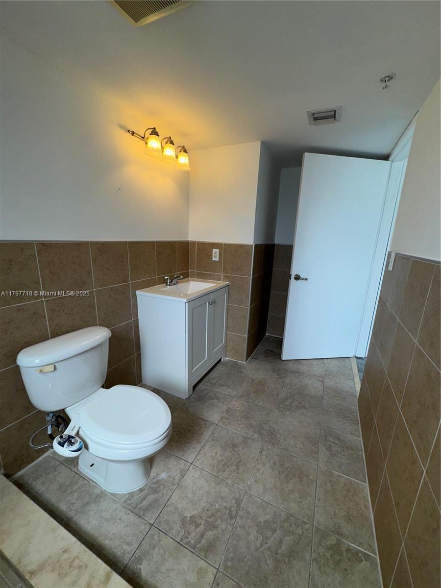498 Southwest 2nd Street, Unit 2D Miami, FL 33130 - Photo 30 of 35 a bathroom with a toilet a sink and a mirror