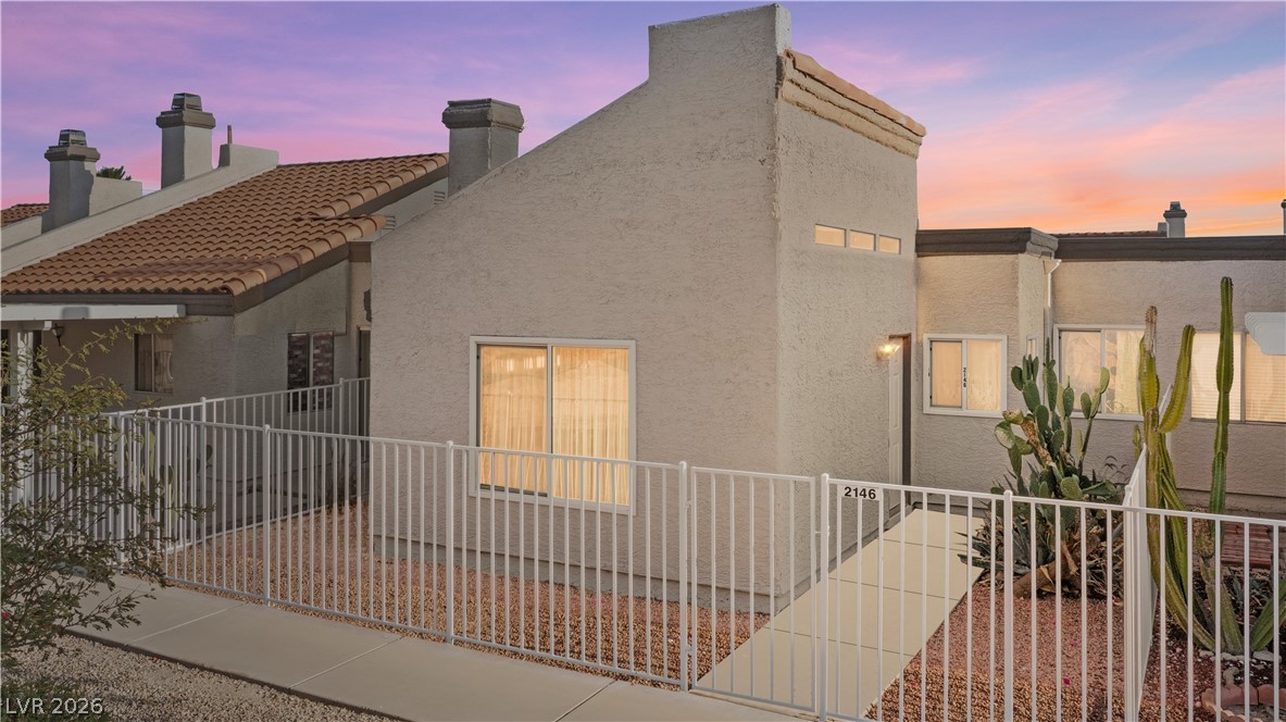 2146 High Dunes Lane Laughlin, NV 89029 - Photo 2 of 64 Back of house at dusk featuring stucco siding, a tiled roof, and fence