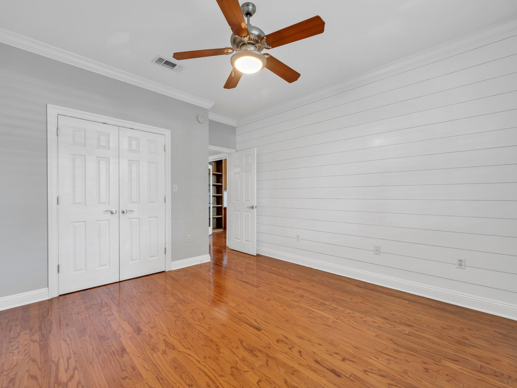 145 Mulry Drive Niceville, FL 32578 - Photo 43 of 58 an empty room with wooden floor and a ceiling fan