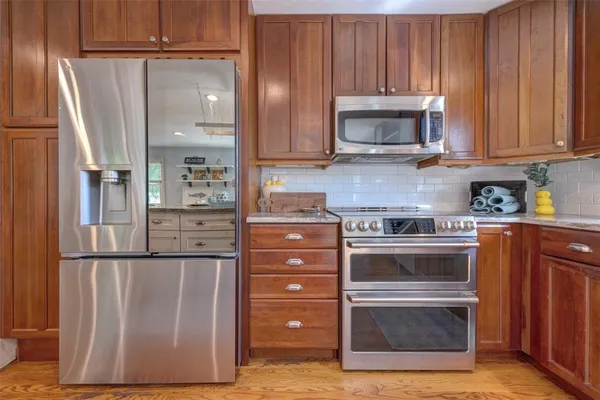 a living room with furniture a chandelier and wooden floor
