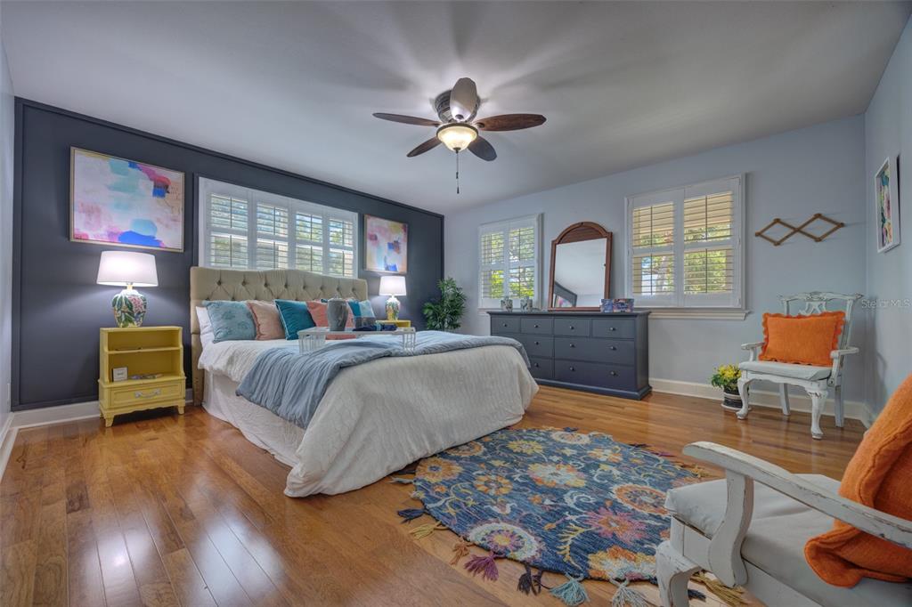 105 Riverside Drive Ormond Beach, FL 32176 - Photo 43 of 100 a spacious bedroom with a large bed and a chandelier