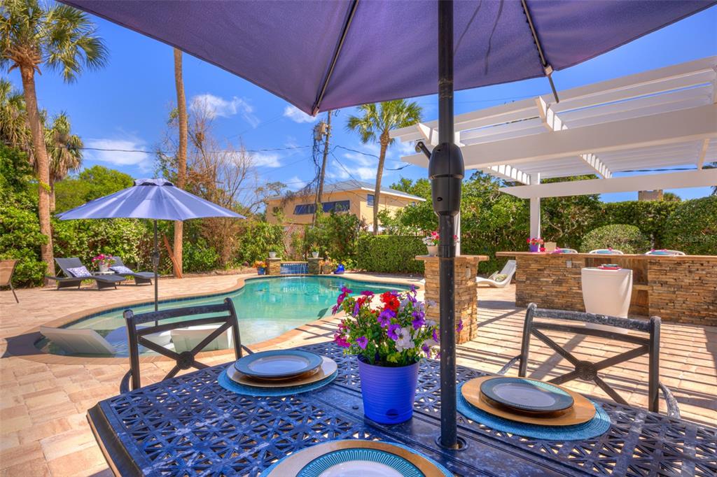 105 Riverside Drive Ormond Beach, FL 32176 - Photo 91 of 100 a patio with a table and chairs under an umbrella