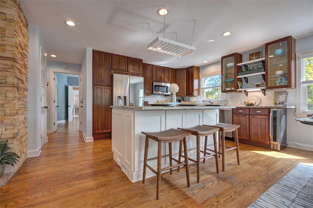 105 Riverside Drive Ormond Beach, FL 32176 - Photo 10 of 100 a kitchen with stainless steel appliances kitchen island granite countertop a table chairs cabinets and wooden floor