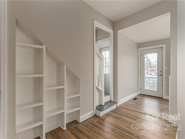 a view of a room with wooden floor and a window