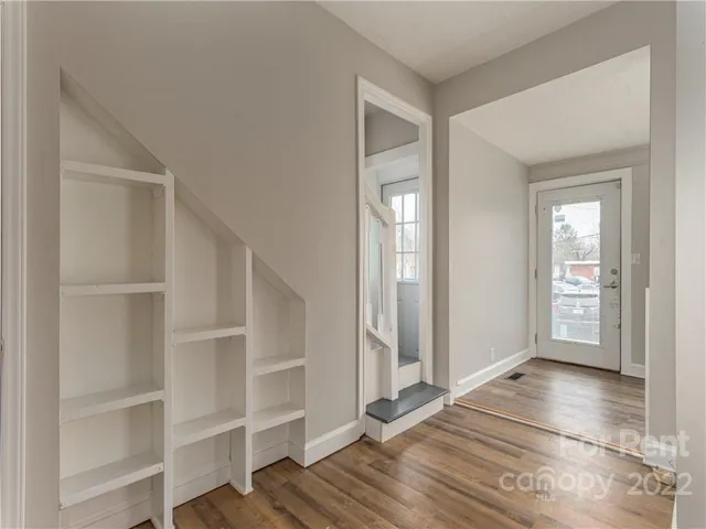a view of a room with wooden floor and a window
