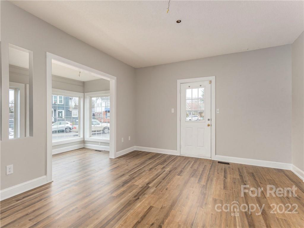 841 Haywood Road Asheville, NC 28806 - Photo 3 of 31 a view of an empty room with wooden floor and a window