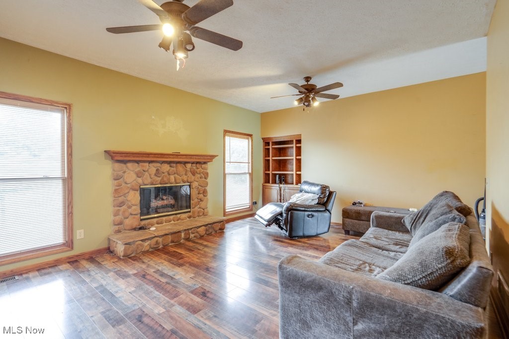 3362 Sunnybrook Road Kent, OH 44240 - Photo 15 of 50 Living room with a ceiling fan, a stone fireplace, and wood finished floors
