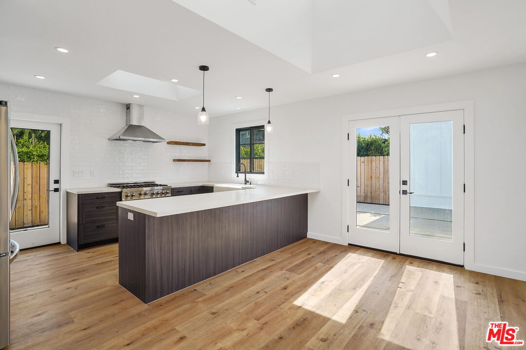 4130 Verdugo View Drive Los Angeles, CA 90065 - Photo 12 of 36 a large kitchen with stainless steel appliances a large counter top a stove a chimney a sink and a large window