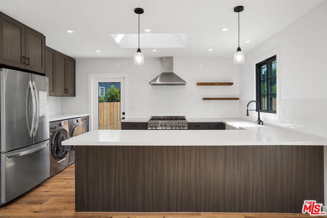 4130 Verdugo View Drive Los Angeles, CA 90065 - Photo 14 of 36 a large kitchen with stainless steel appliances a large counter top a stove a refrigerator and a chandelier