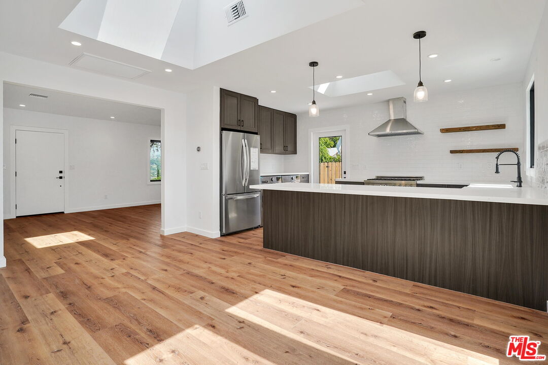 4130 Verdugo View Drive Los Angeles, CA 90065 - Photo 19 of 36 a kitchen with stainless steel appliances kitchen island granite countertop a refrigerator a sink dishwasher and a oven with wooden floor