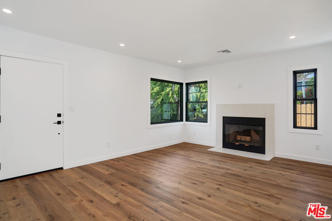 4130 Verdugo View Drive Los Angeles, CA 90065 - Photo 9 of 36 an empty room with wooden floor a fireplace and windows