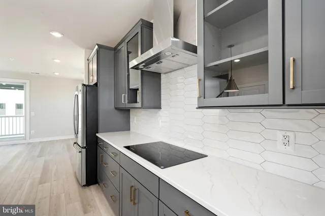 a kitchen with stainless steel appliances a stove a sink and a refrigerator with wooden floor