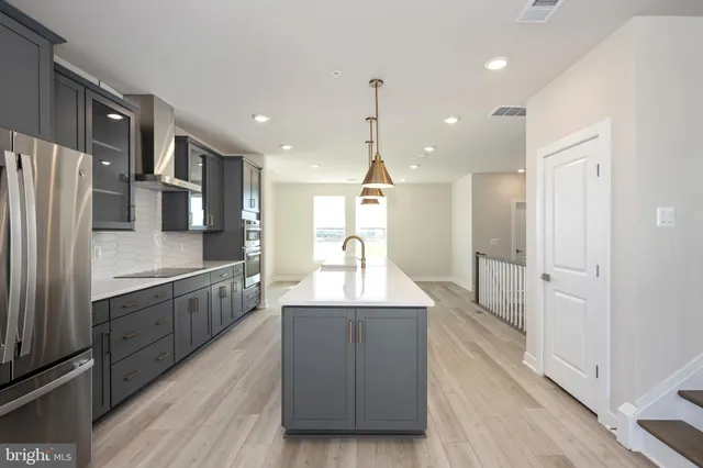 a kitchen with kitchen island granite countertop wooden cabinets and refrigerator