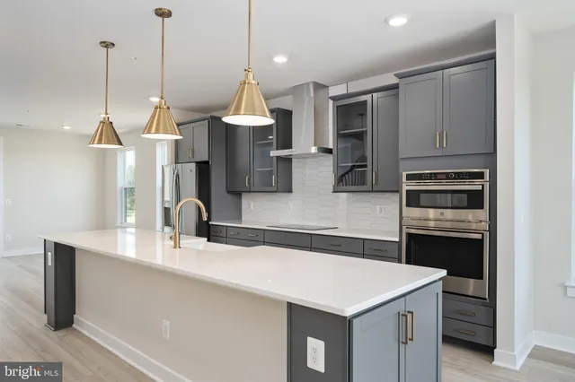 a kitchen with kitchen island a sink stainless steel appliances and cabinets