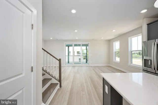 a open kitchen with white cabinets and wooden floor