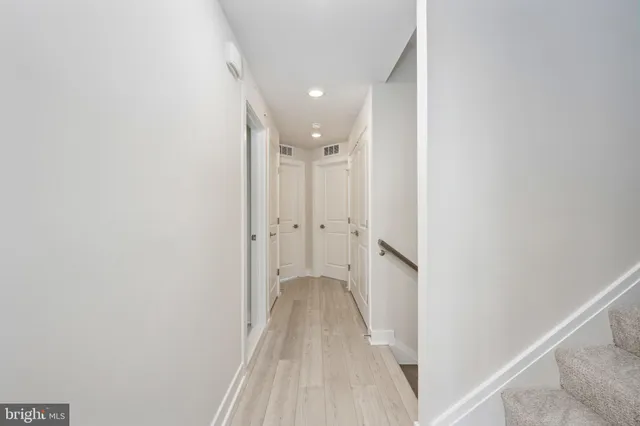 a view of a hallway with wooden floor