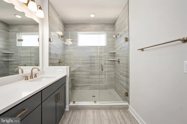 a bathroom with a sink a shower and a mirror