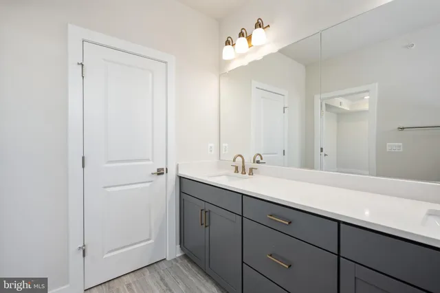 a bathroom with a sink a light fixture a vanity and a mirror