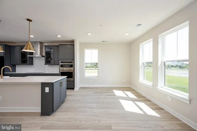 a large kitchen with stainless steel appliances granite countertop a stove a sink and a refrigerator