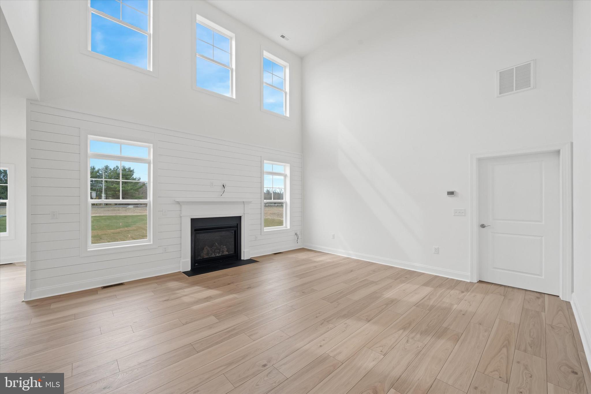 25246 Bethesda Road Georgetown, DE 19947 - Photo 16 of 41 an empty room with windows fireplace and wooden floor