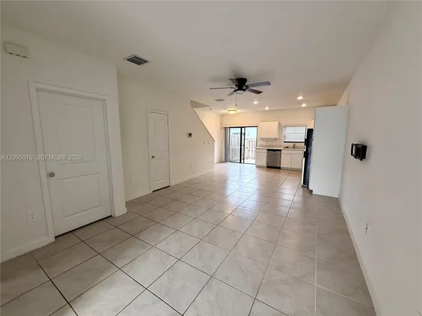 a kitchen with granite countertop a refrigerator and a stove top oven