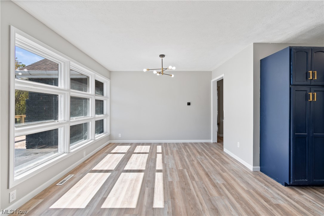 59636 Broadview Road Shadyside, OH 43947 - Photo 6 of 31 Hardwood floored spare room with a notable chandelier