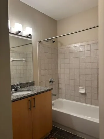 a bathroom with a granite countertop sink a toilet and bathtub