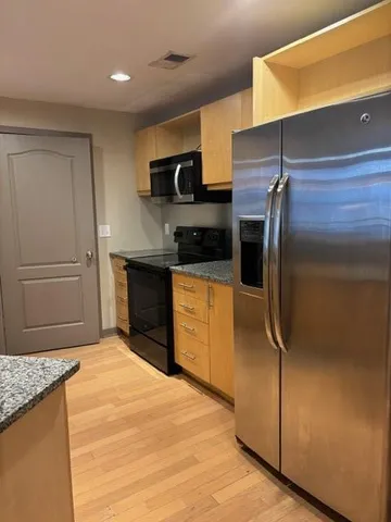 a kitchen with stainless steel appliances granite countertop a refrigerator and a sink