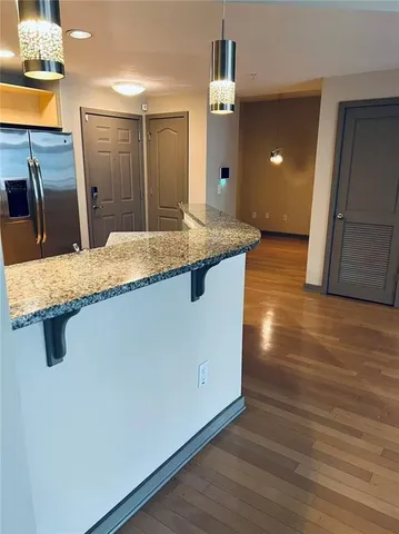 a kitchen with kitchen island sink and wooden floor