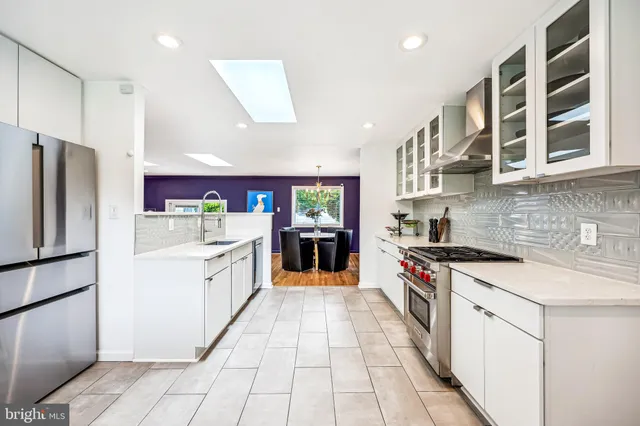 a large kitchen with stainless steel appliances granite countertop a stove and a refrigerator