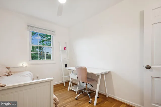 a bedroom with a bed and a wooden floor