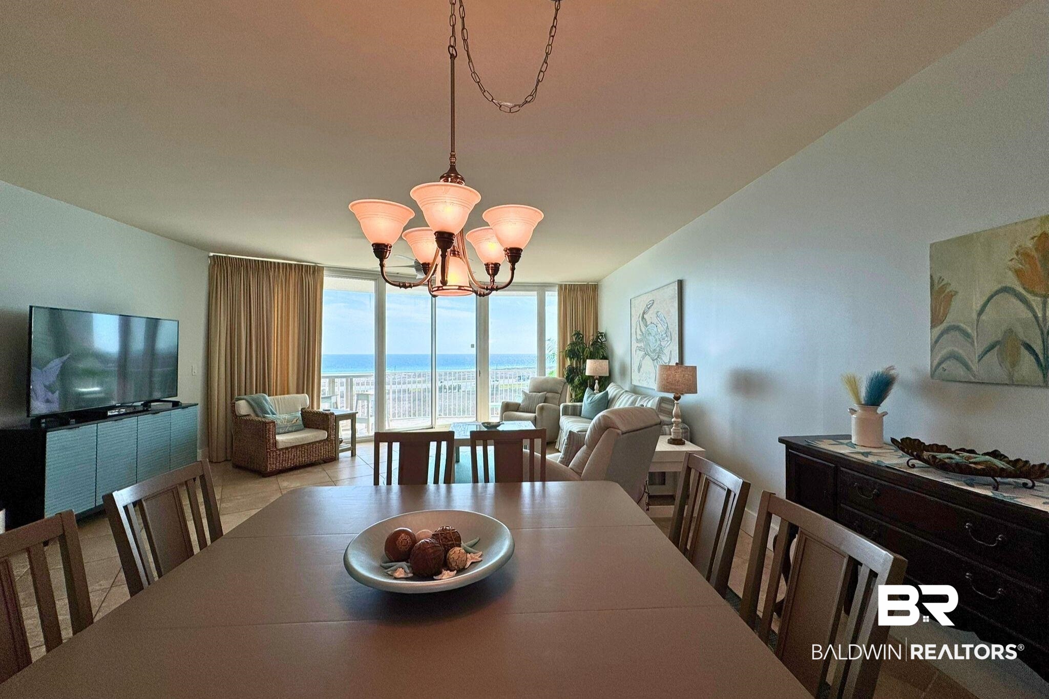 28107 Perdido Beach Boulevard, Unit D714 Orange Beach, AL 36561 - Photo 17 of 88 Dining area with a water view, an inviting chandelier, tile patterned flooring, and expansive windows
