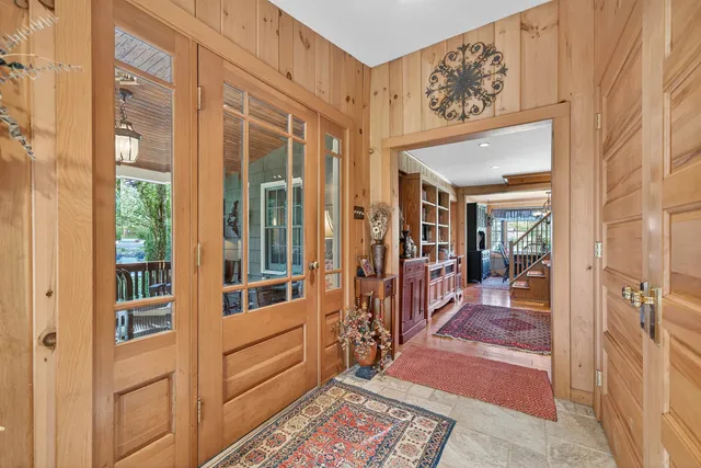 a view of a hallway with wooden floor and windows