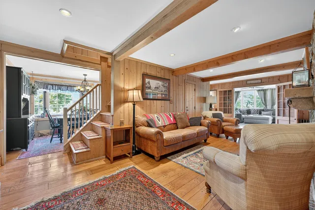 a living room with furniture stairs and a wooden floor