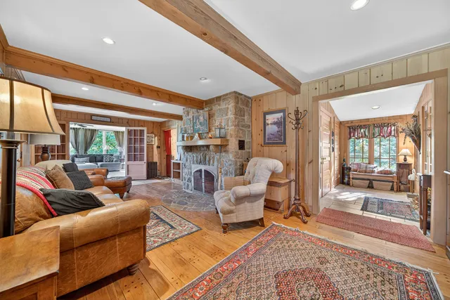 a living room with fireplace furniture and a large window