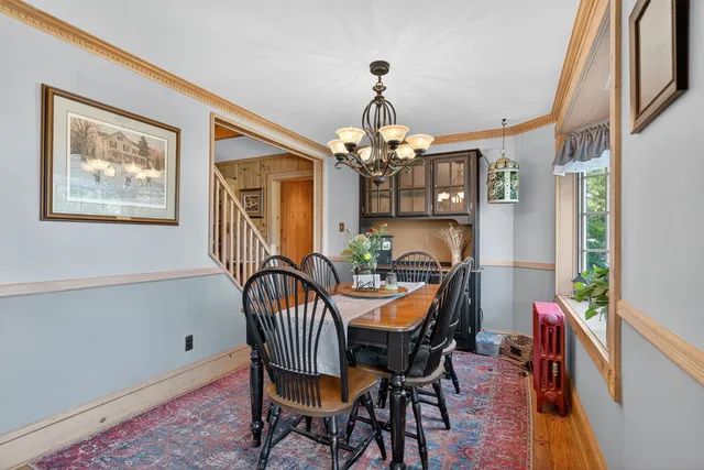 a dining room with furniture a chandelier and wooden floor