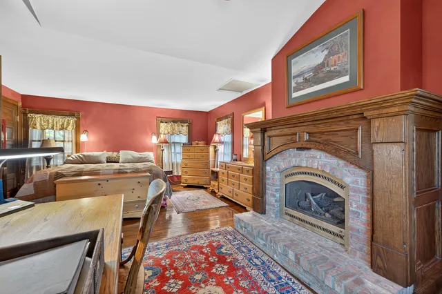 a living room with furniture a rug a fireplace and windows
