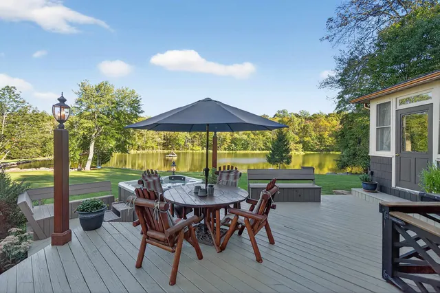 a view of a patio with table and chairs under an umbrella with wooden floor