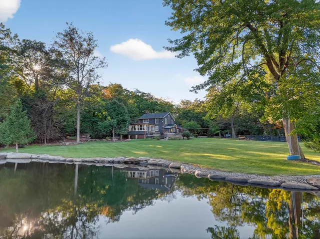 a view of a house with a yard next to a lake