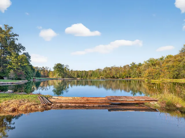 a view of a lake in between two chairs and a table