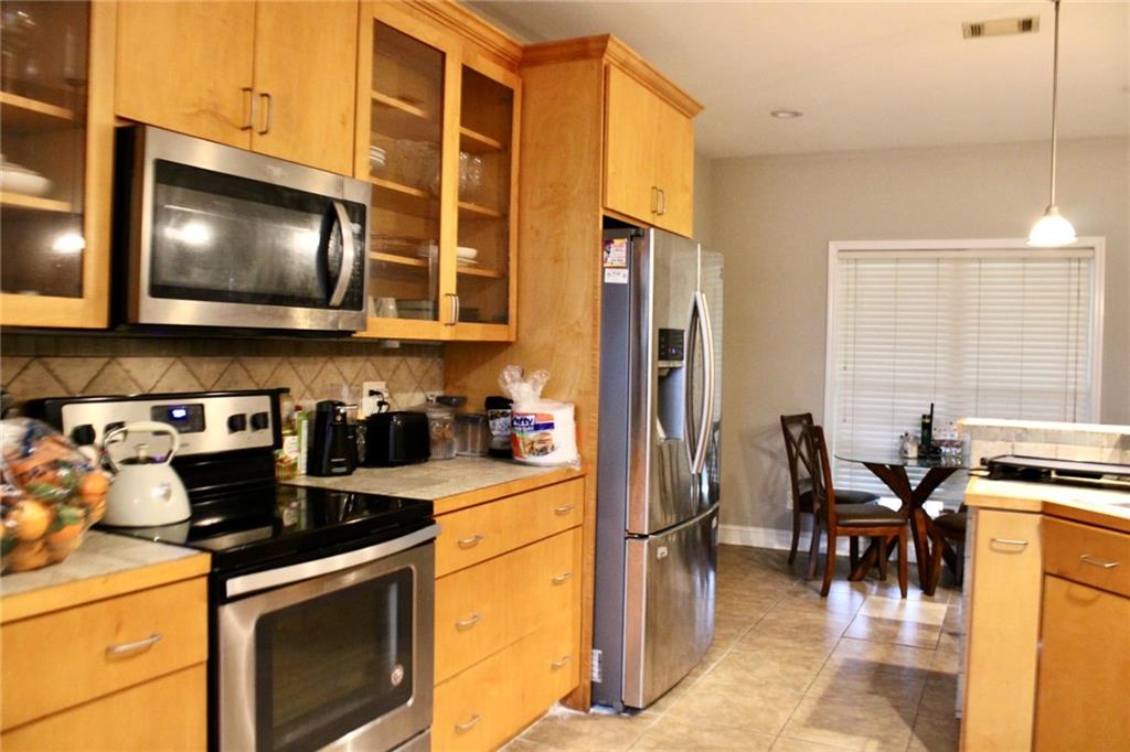 125 Trailwood Road Valdosta, GA 31602 - Photo 6 of 19 a kitchen with stainless steel appliances a stove a microwave a dining table and chairs