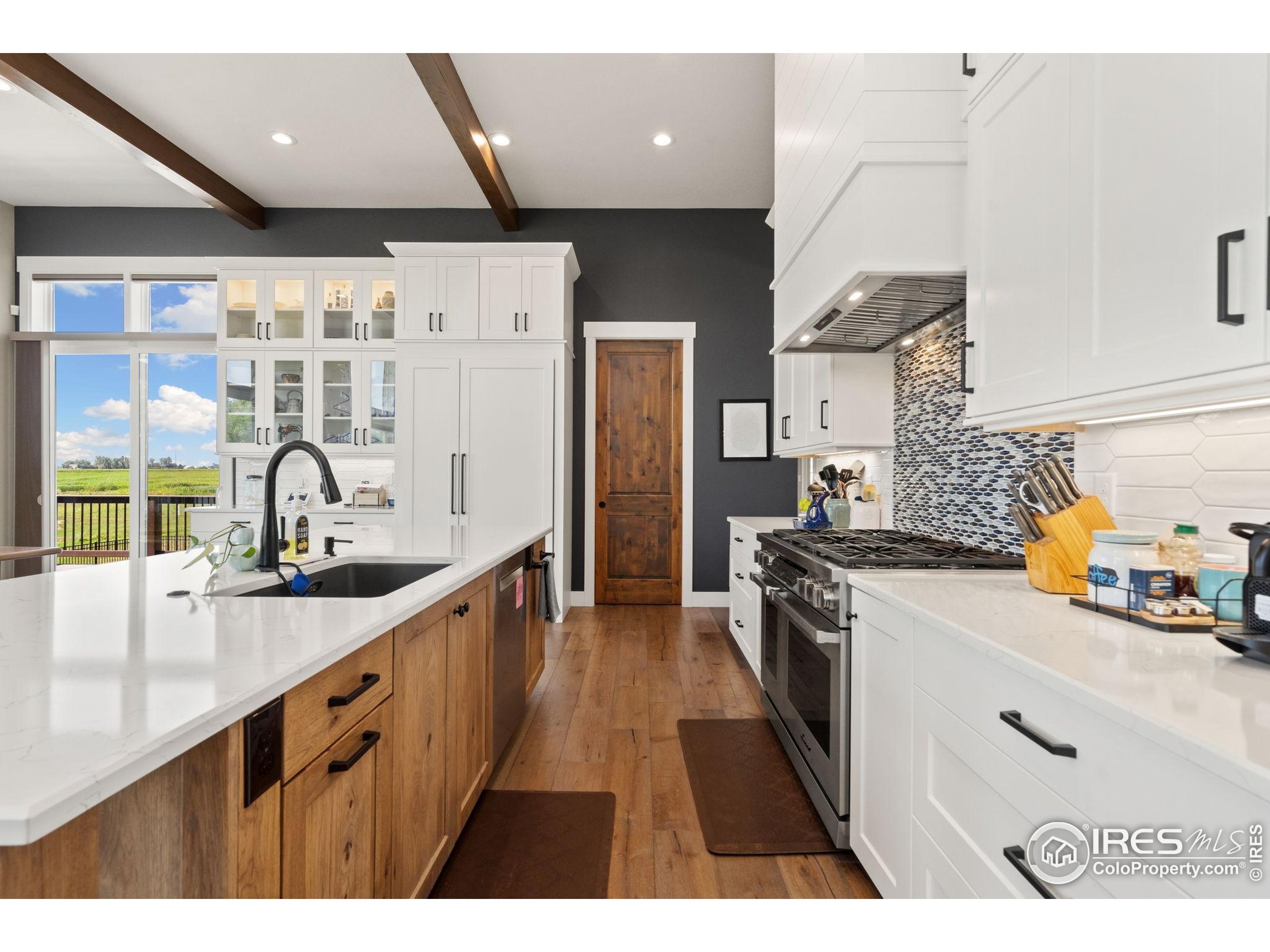 3324 Fox Crossing Place Loveland, CO 80537 - Photo 21 of 47 a kitchen with stainless steel appliances a sink stove and cabinets