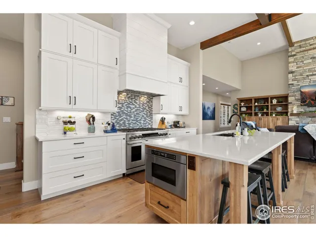 a kitchen with stainless steel appliances kitchen island granite countertop a table chairs and a refrigerator