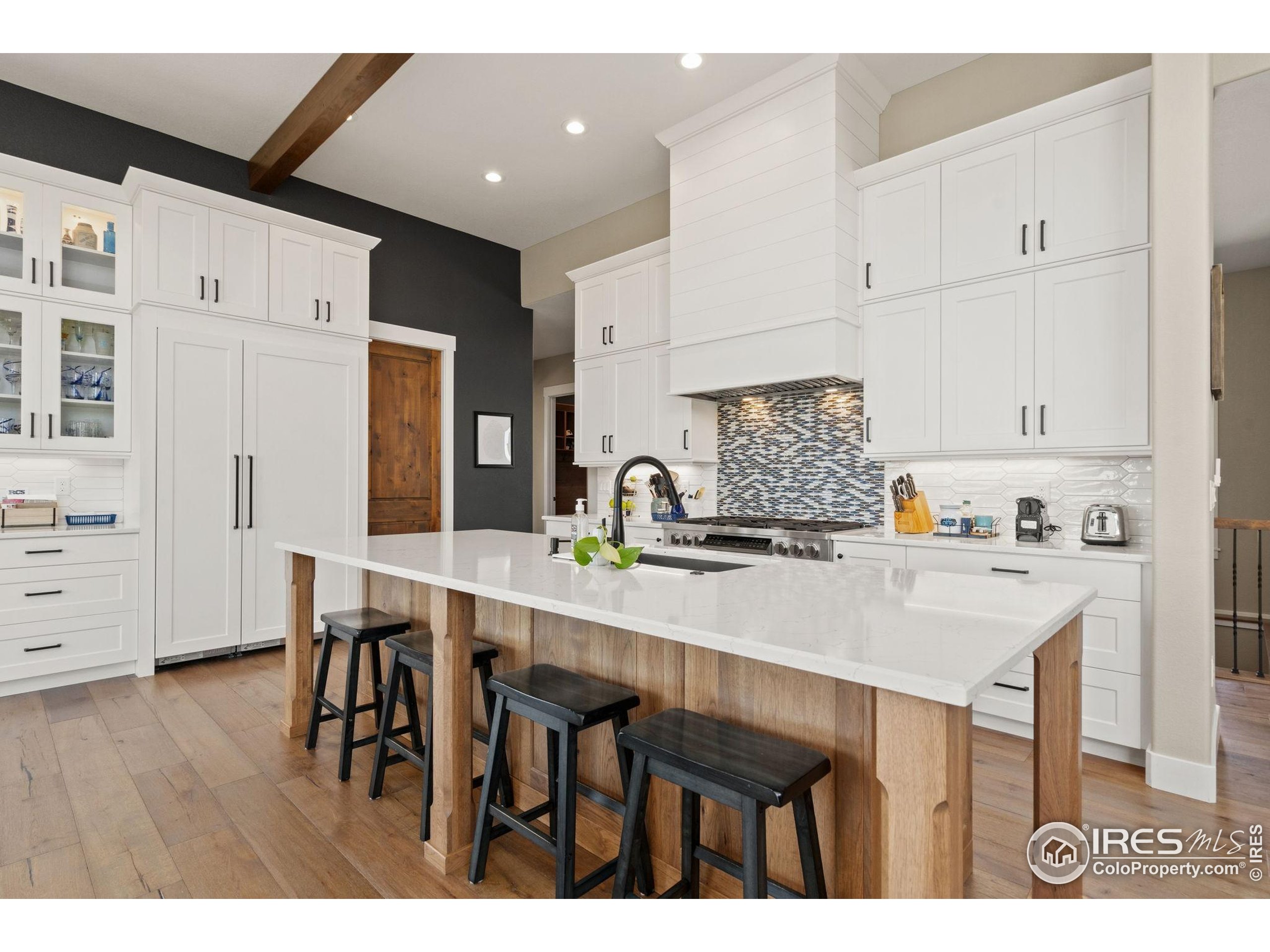 3324 Fox Crossing Place Loveland, CO 80537 - Photo 24 of 47 a kitchen with stainless steel appliances kitchen island granite countertop a table chairs and a refrigerator