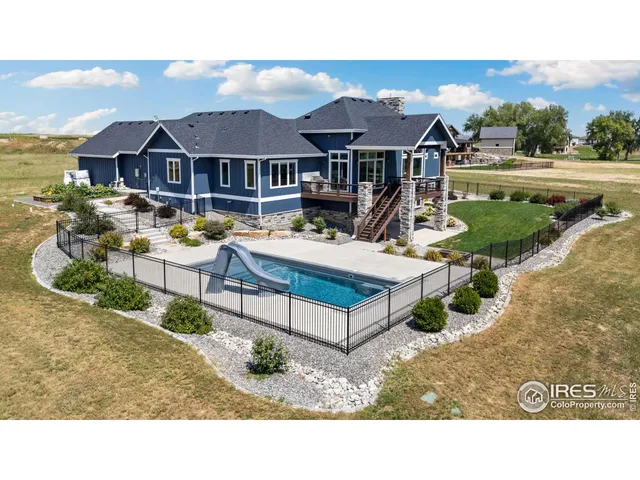 a aerial view of a house with swimming pool and a yard