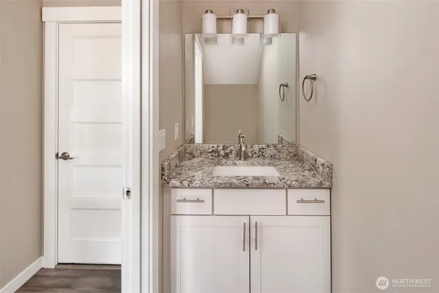a bathroom with a granite countertop sink and a mirror