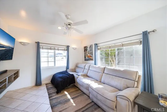 a view of an empty room with window and cabinet area