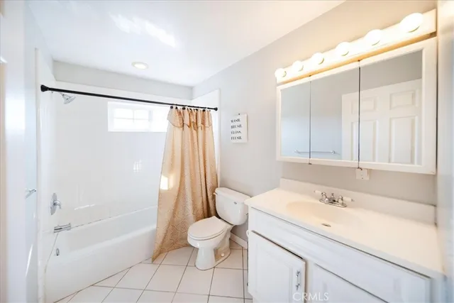 a living room with white cabinets and a wooden floor